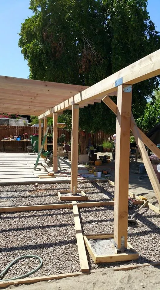 Backyard patio cover being framed with rough-cut lumber.